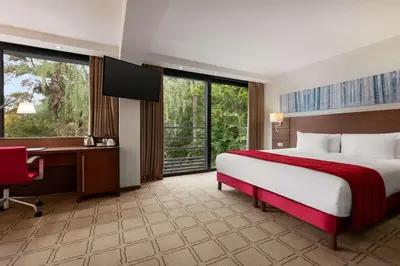 a hotel room with a bed and a desk and a computer at Hotel Dolce La Hulpe Brussels in La Hulpe