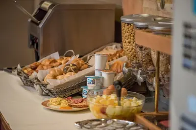 a buffet with bread and pastries on a table at Arass Hôtel & Business Flats in Antwerp
