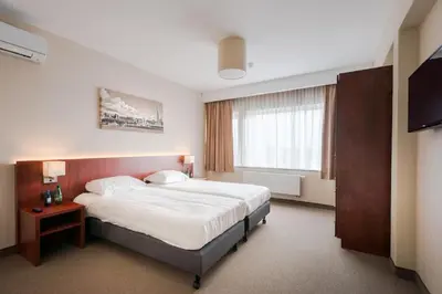 a hotel room with a bed and a window at Arass Hôtel & Business Flats in Antwerp
