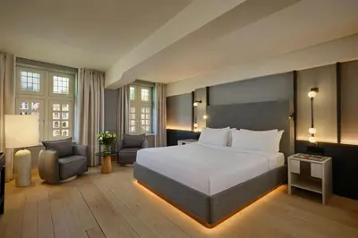 a hotel room with a large bed and a chair at Ghent Marriott Hotel in Ghent