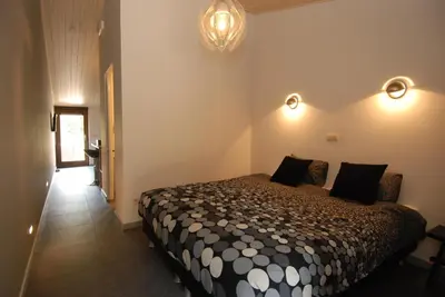 a bedroom with a bed and lights on the wall at Het Schalks Genot in Poppel