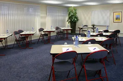a conference room with tables and chairs and a whiteboard at Citadines Sainte-Catherine Brussels in Brussels