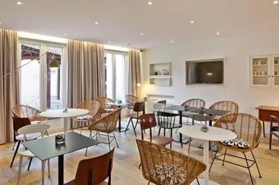 a restaurant with tables and chairs and windows at Citadines Sainte-Catherine Brussels in Brussels