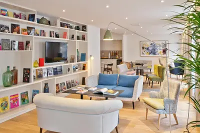 a living room with a blue couch and chairs at Citadines Sainte-Catherine Brussels in Brussels