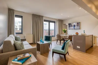 a living room with a couch and a table at Citadines Toison d'Or Brussels in Brussels