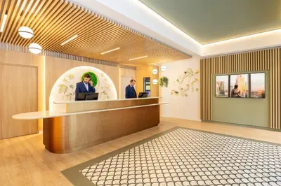 a lobby with two men at a reception desk at Citadines Toison d'Or Brussels in Brussels