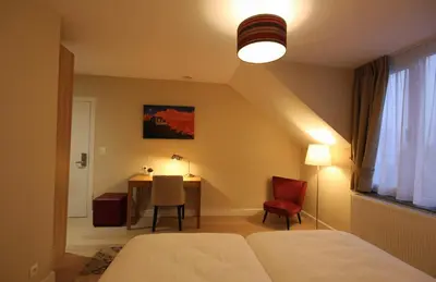 a bedroom with a bed and a table and a lamp at Hooome in Brussels