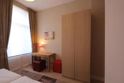 a bedroom with a closet and a bed and a table at Hooome in Brussels