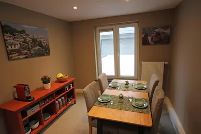 a dining room with a table and chairs and a window at Hooome in Brussels