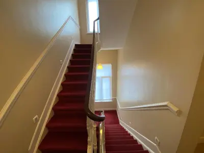 a staircase with red carpeting and a window at Hooome in Brussels