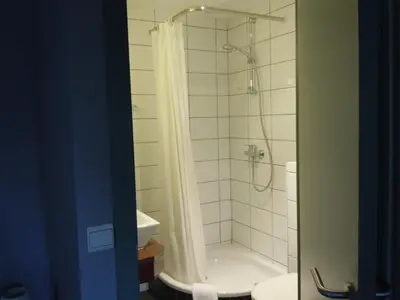 a bathroom with a shower with a shower curtain at Hotel Malcot in Mechelen
