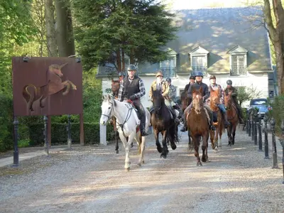 a group of people riding horses down a street at Hotel Malcot in Mechelen