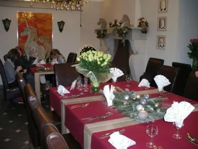 a dining room with red tablecloths and people sitting at tables at Hotel Malcot in Mechelen
