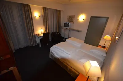 a hotel room with a bed and a desk at Hotel Malcot in Mechelen