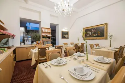 a restaurant with tables and chairs and a chandelier at Hotel The Lord in Ghent