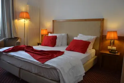 a hotel room with two beds with red pillows at Hotel The Lord in Ghent
