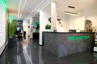 a lobby with a reception counter and plants at Hotel City Center in Brussels