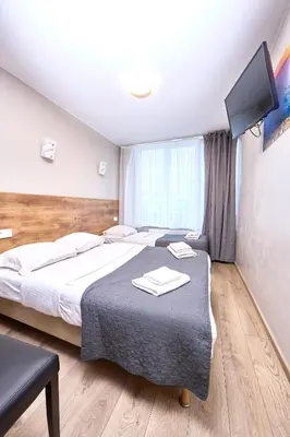 a bedroom with two beds and a flat screen tv at Hotel City Center in Brussels