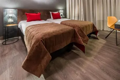 two beds in a hotel room with red pillows at Martin's Brussels EU in Brussels