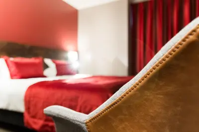 a chair in a hotel room with a bed at Martin's Brussels EU in Brussels