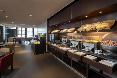 a restaurant with a buffet line with bread at Martin's Brussels EU in Brussels