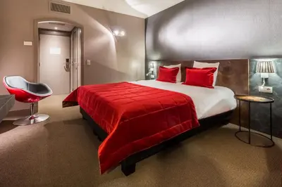 a bedroom with a red bed and a red chair at Martin's Brussels EU in Brussels