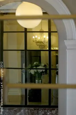 a window with a chandelier and a vase of flowers at Hotel La Legende in Brussels