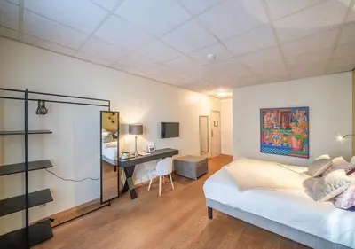 a bedroom with a bed and a desk in it at Hotel La Legende in Brussels