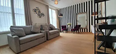 a living room with a couch and a table at Hotel La Legende in Brussels