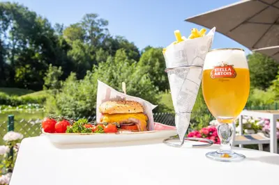 a table with a plate of food and a glass of beer at Crowne Plaza Brussels Airport by IHG in Zaventem