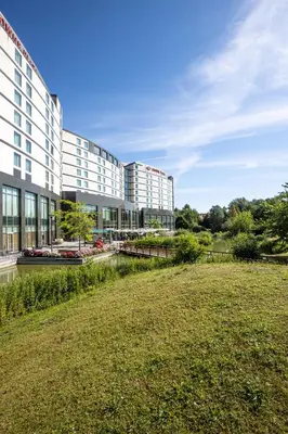 a large building with a grass field in front of it at Crowne Plaza Brussels Airport by IHG in Zaventem