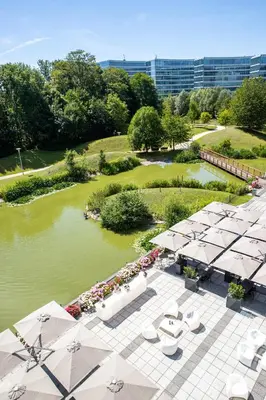 an overhead view of a pool of water with tables and umbrellas at Crowne Plaza Brussels Airport by IHG in Zaventem