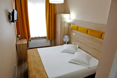 a bedroom with a white bed and a window at Hotel de France in Brussels