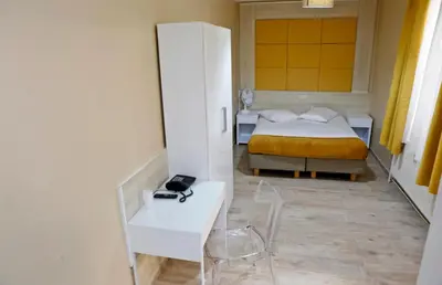 a bedroom with a bed and a desk and a table at Hotel de France in Brussels