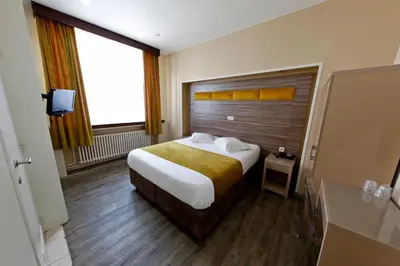 a bedroom with a large bed and a large window at Hotel de France in Brussels