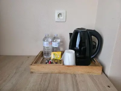 a tray with a tea kettle and two bottles of water at Hotel de France in Brussels