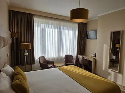 a hotel room with a bed and chairs and a window at Hotel de France in Brussels