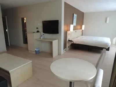 a hotel room with a bed and a table and a tv at Hotel Panorama in Overijse