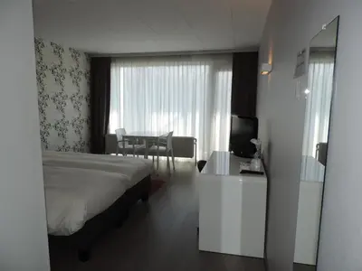 a hotel room with a bed and a table and a television at Hotel Panorama in Overijse