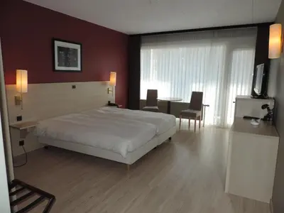 a bedroom with a bed and a table and a television at Hotel Panorama in Overijse