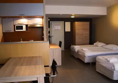 a hotel room with two beds and a kitchen at City Apartments Antwerpen in Antwerp