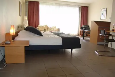a large bed in a room with a large window at City Apartments Antwerpen in Antwerp