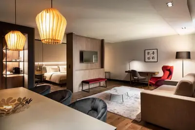 a living room with a couch and a room with a bed at Radisson Collection Grand Place Brussels in Brussels