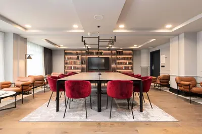 a conference room with a table and red chairs at Radisson Collection Grand Place Brussels in Brussels