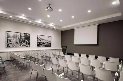 a conference room with white chairs and a screen at Radisson Collection Grand Place Brussels in Brussels