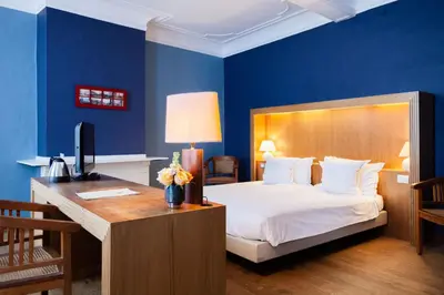 a bedroom with a bed and a desk with a computer at Hotel Hof van Aragon in Lier