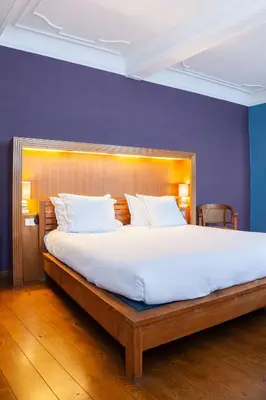 a bedroom with a large bed with a wooden headboard at Hotel Hof van Aragon in Lier