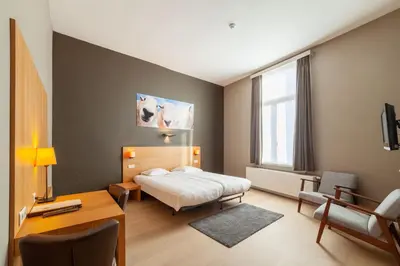 a hotel room with a bed and a desk and a desk at Hotel Hof van Aragon in Lier