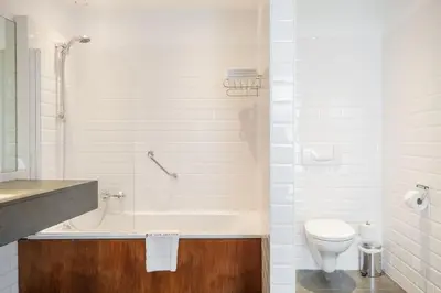 a bathroom with a tub and a toilet and a sink at Hotel Hof van Aragon in Lier