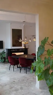 a living room with a table and chairs and a piano at Hotel Hof van Aragon in Lier